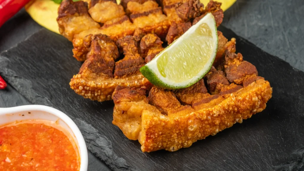 torresmo servido com acompanhamentos e limão